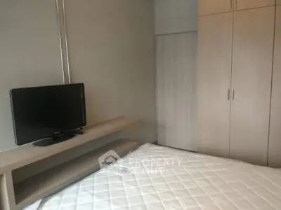 Modern bedroom with built-in wardrobe and mounted TV, perfect for cozy living.