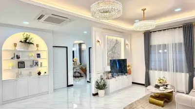 Luxurious living room with elegant decor, marble accents, and modern lighting fixtures.
