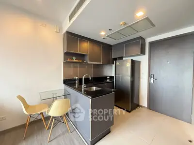 Modern kitchen with sleek cabinets and dining area in a stylish apartment.