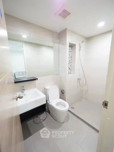 Modern bathroom with sleek design, featuring a shower and contemporary fixtures.