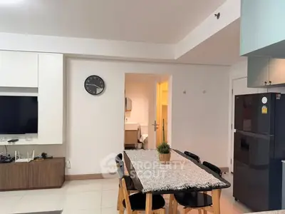 Modern dining area with sleek furniture and wall-mounted TV in a stylish apartment.