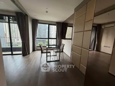 Spacious modern living room with large windows and balcony view in urban apartment.