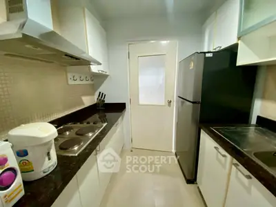 Modern kitchen with sleek countertops and appliances in a cozy layout.