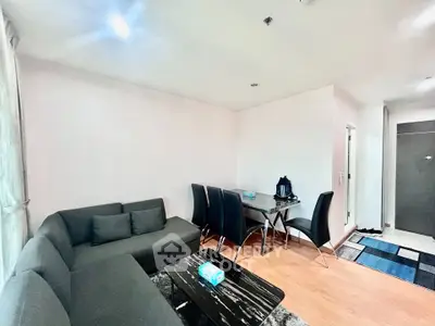 Modern living room with sleek black furniture and wooden flooring