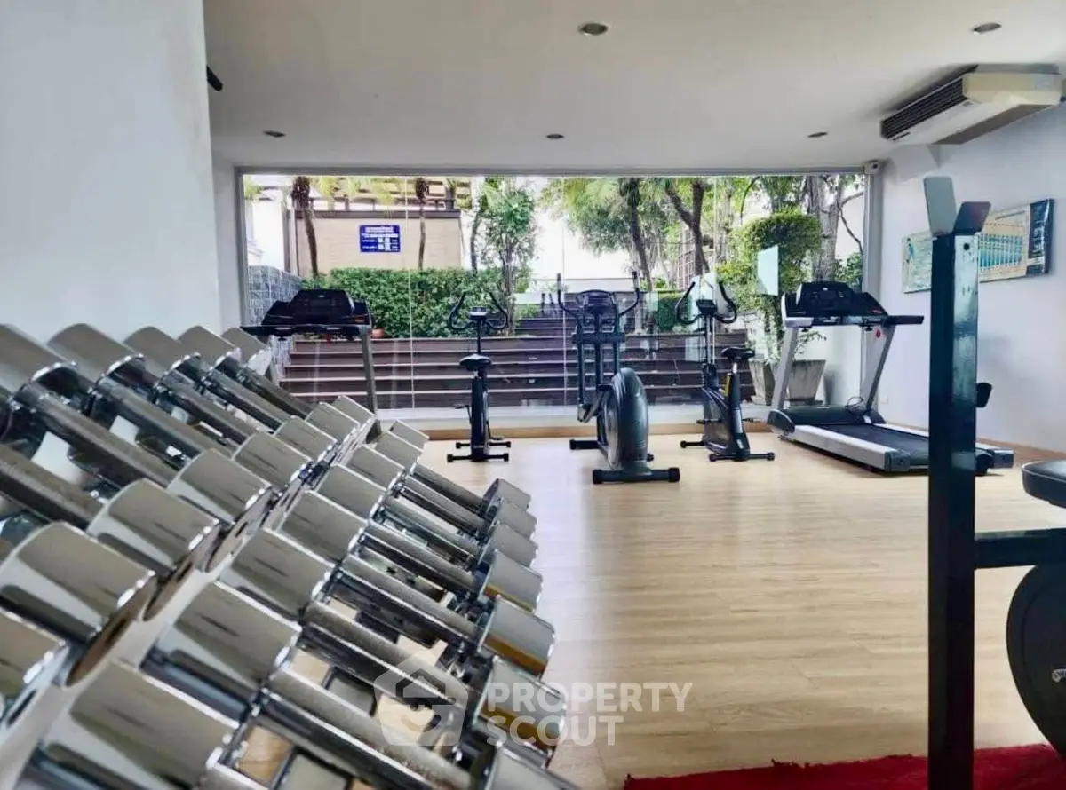 Modern gym with state-of-the-art equipment and large windows offering a refreshing view.