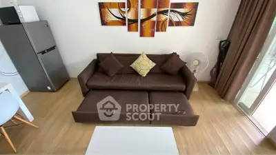 Modern living room with brown sofa bed, stylish wall art, and natural light from balcony.