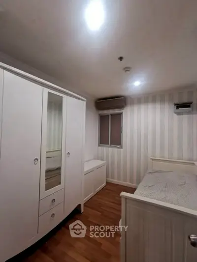 Cozy bedroom with stylish wardrobe and wooden flooring