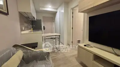 Modern living room with sleek furniture and open kitchen layout in a cozy apartment.