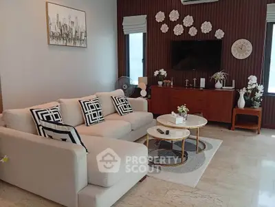 Elegant living room with modern decor, featuring a cozy sofa, stylish coffee tables, and wall art for a chic ambiance.