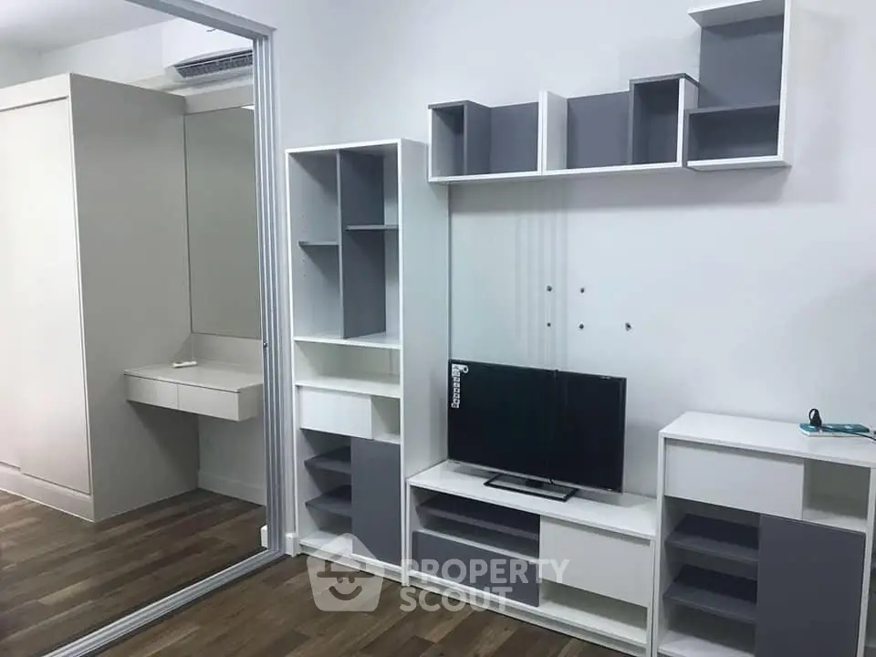 Modern living room with sleek shelving and mounted TV in stylish apartment