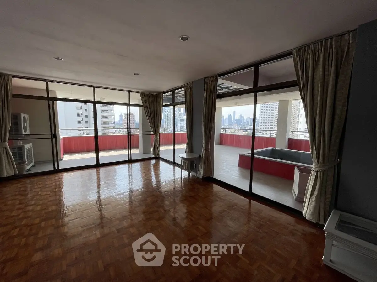Spacious living room with large windows and city view balcony, perfect for urban living.