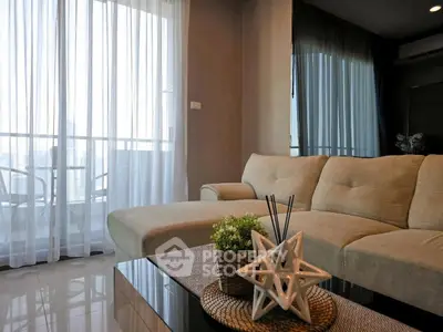 Modern living room with elegant decor and large windows offering natural light.