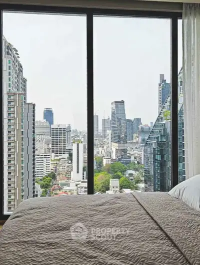 Stunning cityscape view from a modern bedroom window in a high-rise apartment.