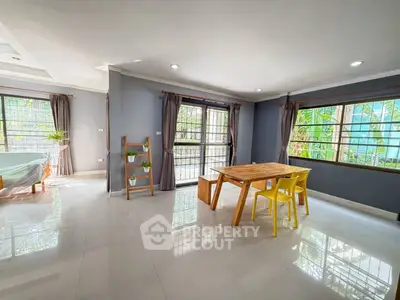 Spacious modern living room with large windows and stylish dining area