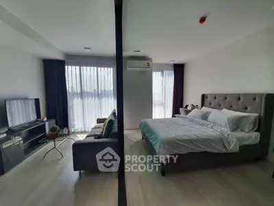Spacious modern bedroom with large windows and stylish decor in a high-rise apartment.