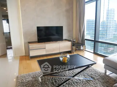 Modern living room with large windows and city view, featuring sleek furniture and stylish decor.