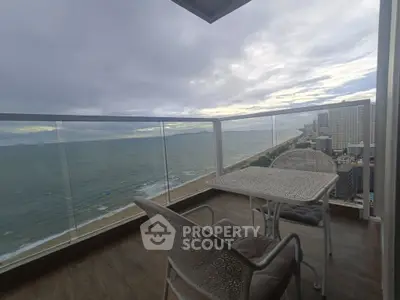 Stunning ocean view from high-rise balcony with elegant outdoor seating.