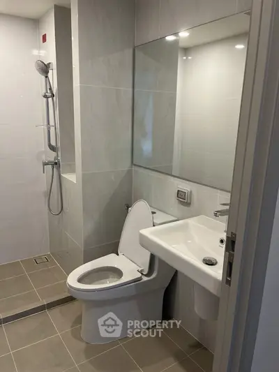 Modern bathroom with sleek fixtures and walk-in shower in a contemporary apartment.