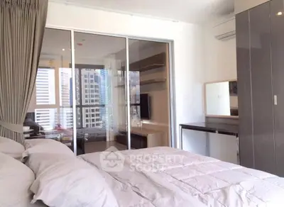 Modern bedroom with city view and sliding glass doors to a cozy study area.