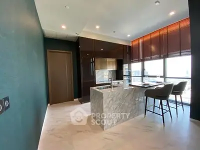 Luxurious modern kitchen with marble island and panoramic city views.