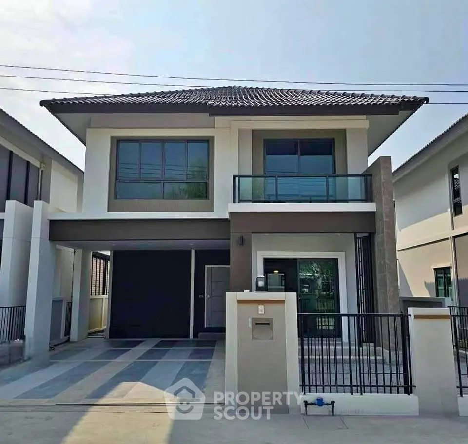 Modern two-story house with sleek design and spacious driveway in suburban neighborhood.