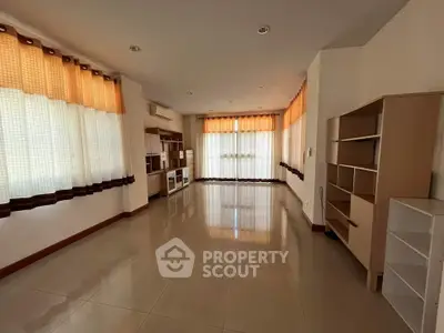 Spacious living room with large windows and built-in shelves, perfect for modern living.