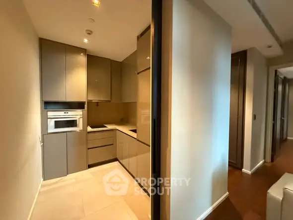 Modern kitchen with sleek cabinetry and built-in oven in a stylish apartment.