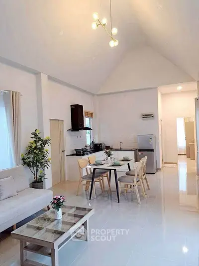 Spacious open-plan living and dining area with modern kitchen in a bright, airy home.
