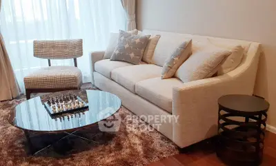 Elegant living room with modern sofa, stylish chair, and chic coffee table in cozy setting.