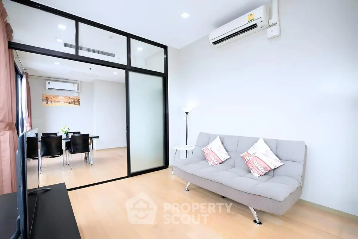 Modern living room with sleek glass partition and cozy seating area