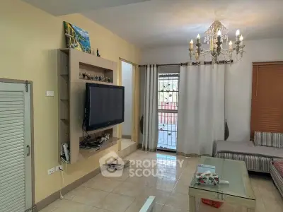 Cozy living room with chandelier and wall-mounted TV in a modern home.