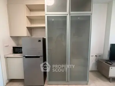 Modern kitchen with sleek fridge and microwave in compact layout