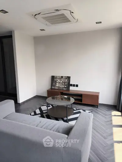 Modern living room with sleek furniture and stylish decor, featuring a cozy gray sofa and chic coffee table.
