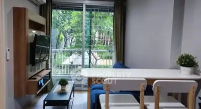 Modern living room with balcony view, stylish furniture, and natural light.