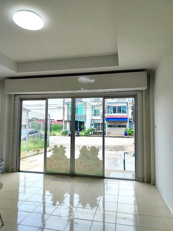 Spacious room with large glass doors and outdoor view, ideal for natural light.