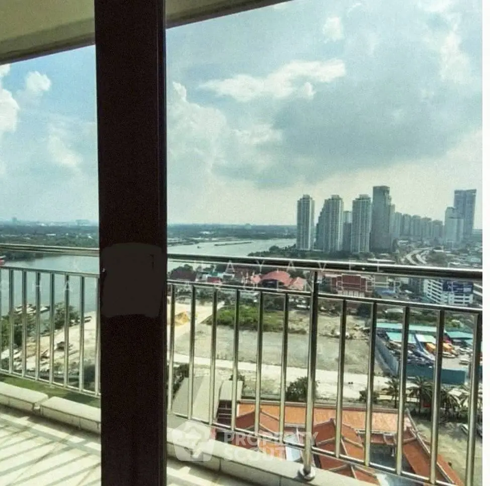 Stunning high-rise balcony view overlooking city skyline and river, perfect for urban living.