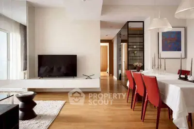 Modern living room with sleek design, red chairs, and a large TV, perfect for stylish urban living.