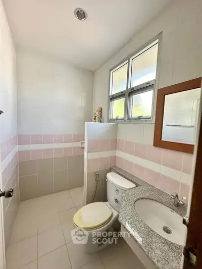 Bright bathroom with modern fixtures and natural light through large windows.
