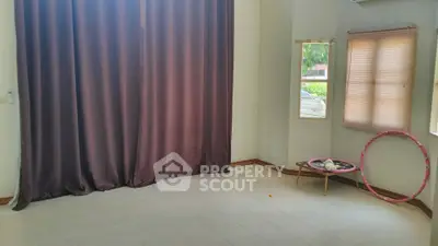 Spacious empty room with large window and elegant curtains