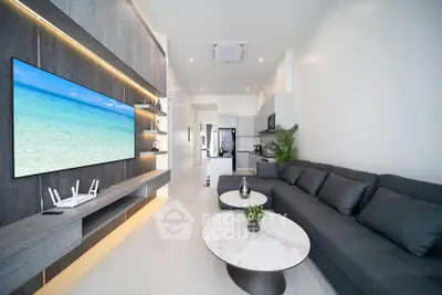 Modern living room with sleek design, large TV, and open kitchen layout in a stylish apartment.