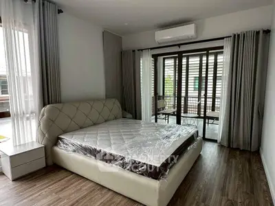 Spacious bedroom with modern decor and balcony access in a stylish home.