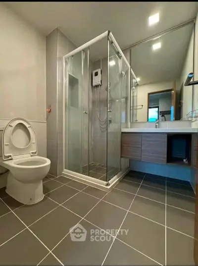 Modern bathroom with glass shower and sleek fixtures in a contemporary home.