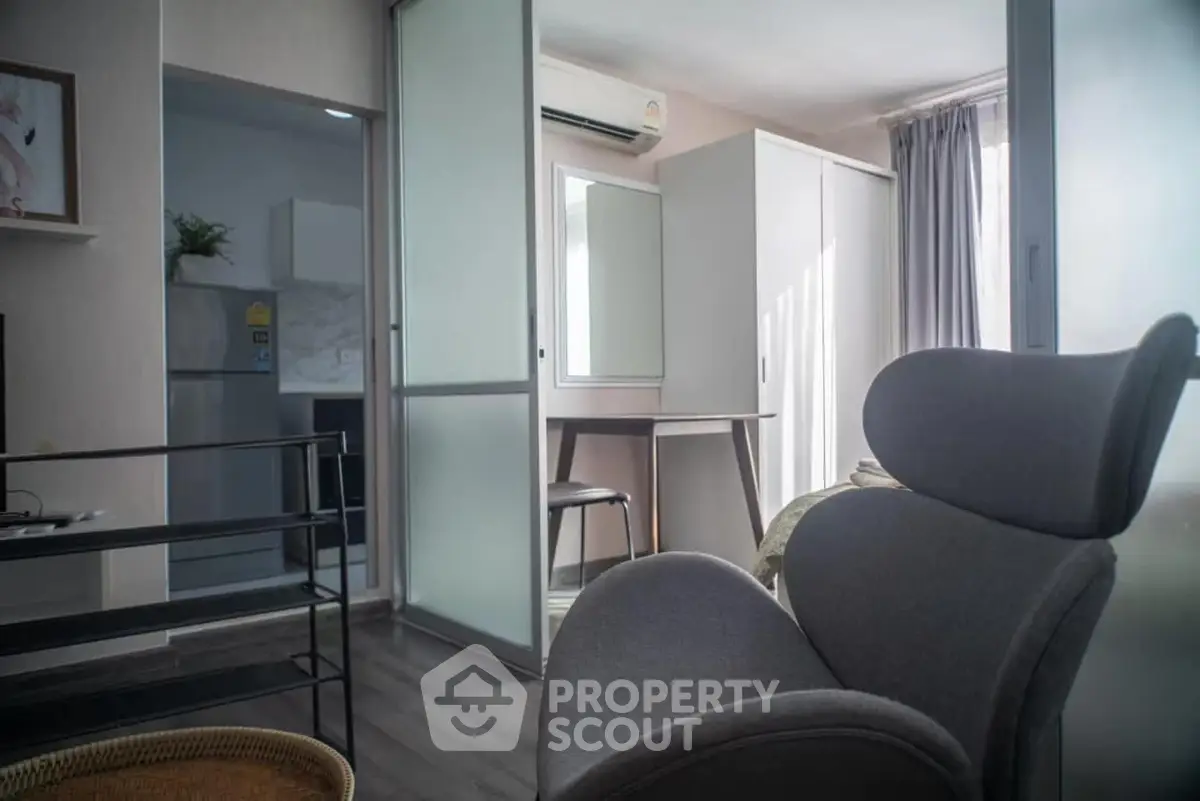 Modern living room with sleek furniture and natural light, featuring a cozy workspace and stylish decor.