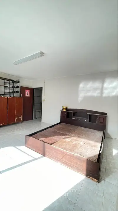 Spacious bedroom with natural light and wooden furniture, ideal for cozy living.