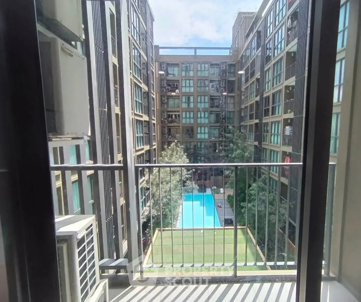 Modern apartment balcony with pool view in urban setting