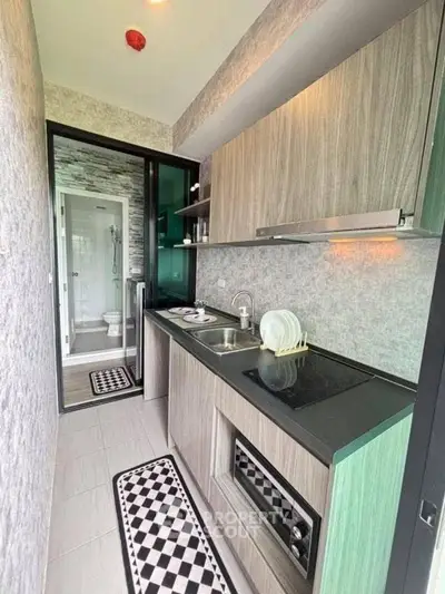 Modern compact kitchen with sleek cabinetry and built-in appliances in a stylish apartment.