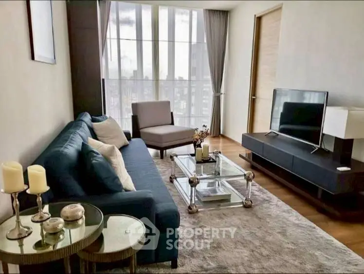 Modern living room with stylish furniture and large windows offering city views.