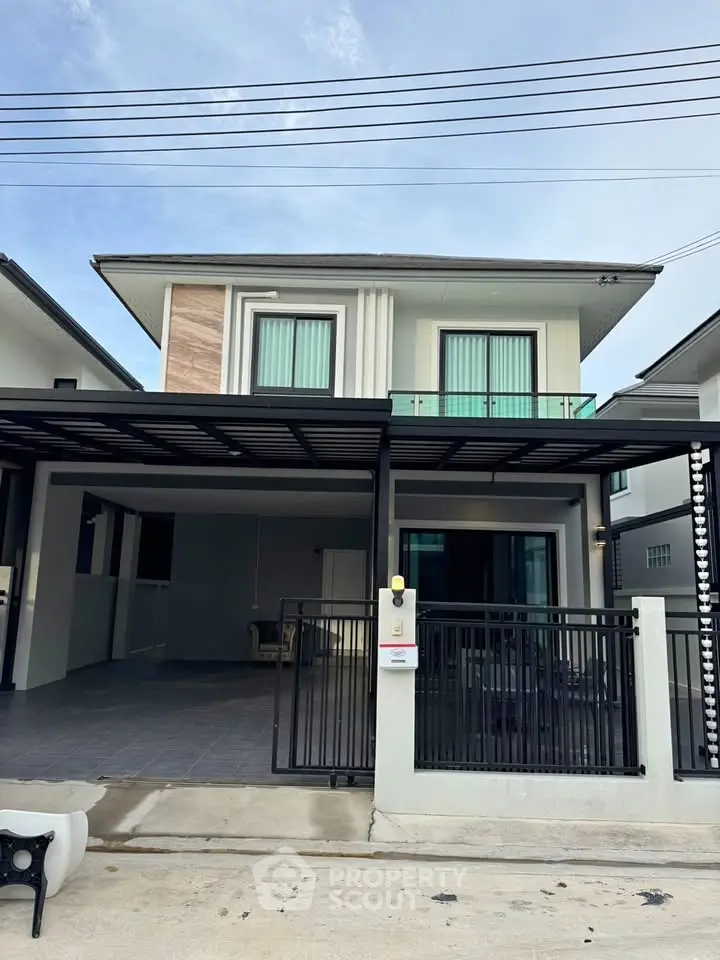 Modern two-story house with sleek design and spacious driveway in a suburban neighborhood.