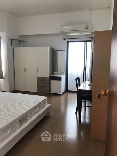 Spacious bedroom with modern furniture and balcony access in a stylish apartment.