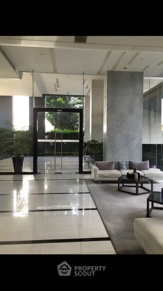 Luxurious modern building lobby with elegant seating and glass entrance, perfect for upscale living.